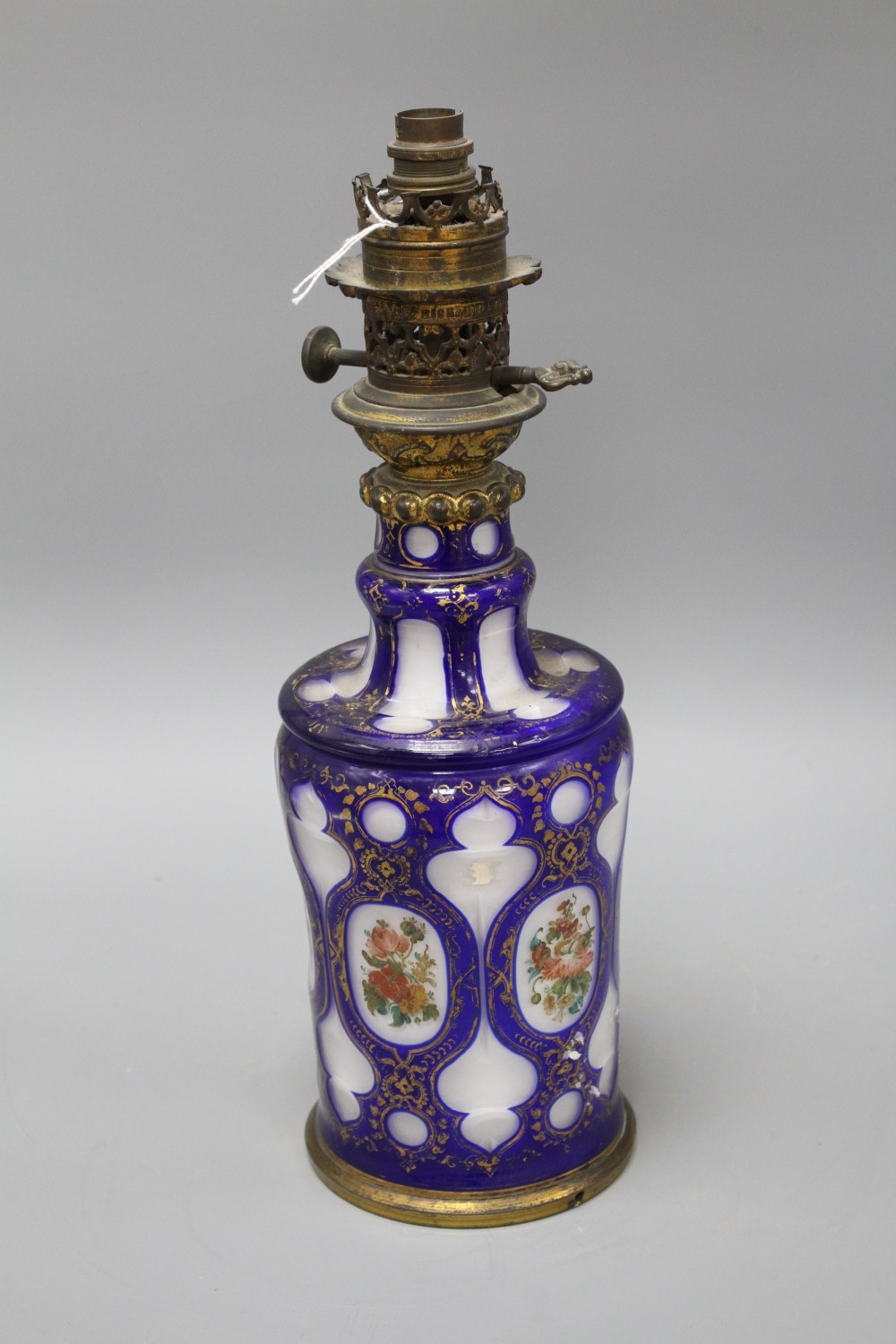 A Bohemian blue overlaid glass oil lamp base, painted with flowers, overall height 42.5cm